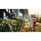 Professional gardener uses an electric hedge trimmer to precisel